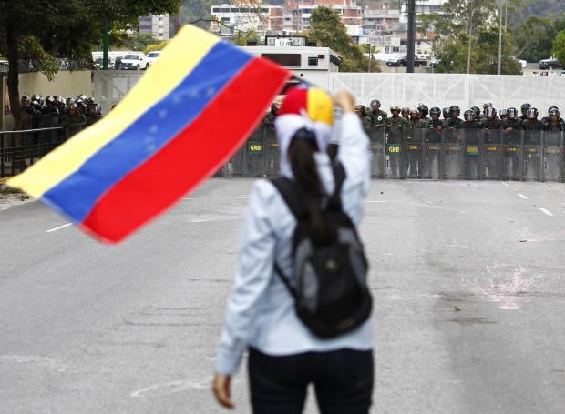 A protester stares down riot police during demonstrations in Venezuela