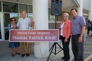 Mr. Ruffing and members of the Kindt family with the sign honoring Thomas Patrick Kindt '58