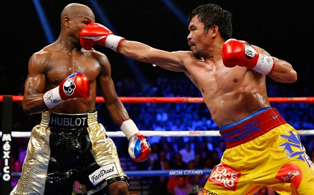 LAS VEGAS, NV - MAY 02:  Manny Pacquiao throws a right at Floyd Mayweather Jr. during their welterweight unification championship bout on May 2, 2015 at MGM Grand Garden Arena in Las Vegas, Nevada.  (Photo by Al Bello/Getty Images)