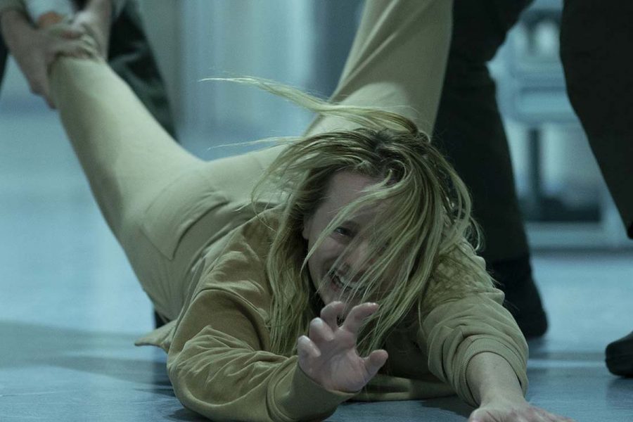 Elisabeth Moss being dragged by the Invisible Man in the insane asylum