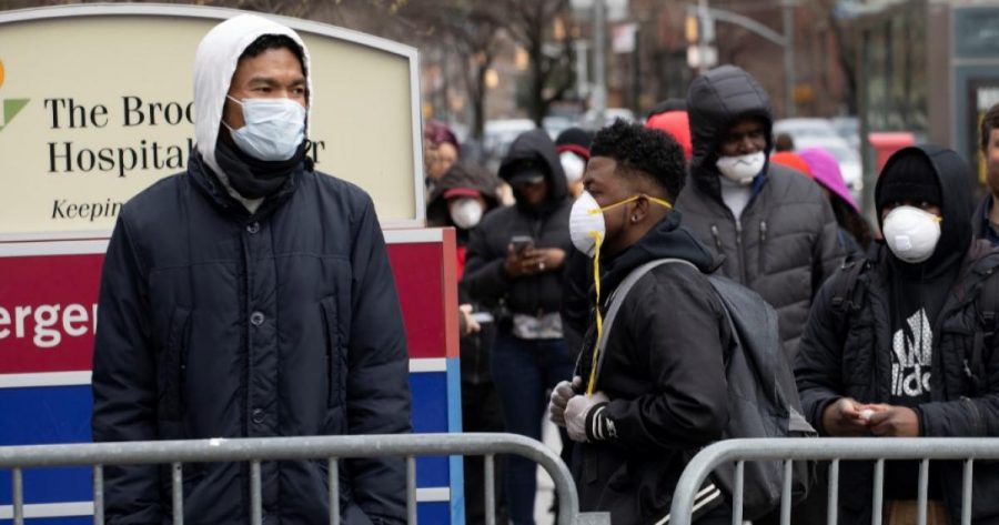 People wait in line to be screened for the coronavirus at the Brooklyn Hospital Center, New York, March 19, 2020.