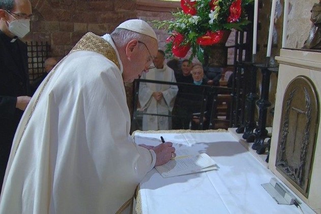 Pope Francis signs his newest work