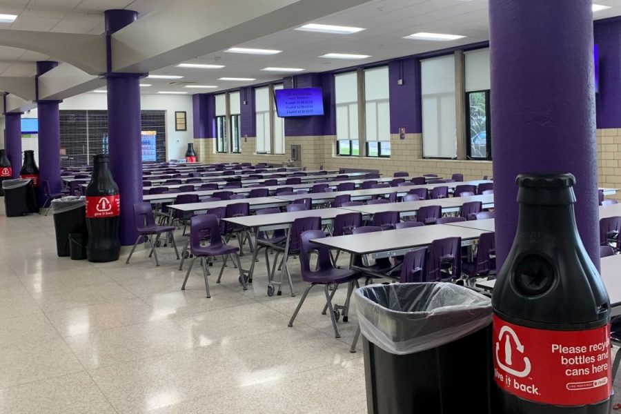 The cafeteria tables, where most students are seated to eat lunch.