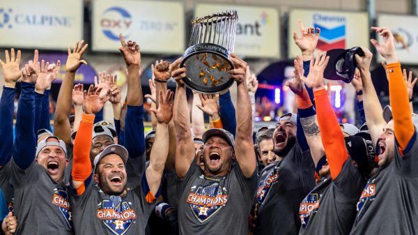 The Astros team is holding up the world series trophy after beating the Phillies in 2022.